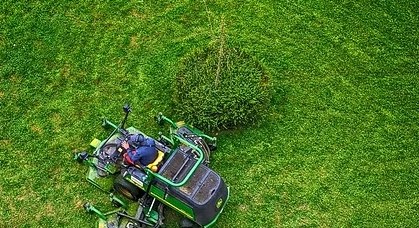 Ride-on mower cutting a large lawn, seen from above