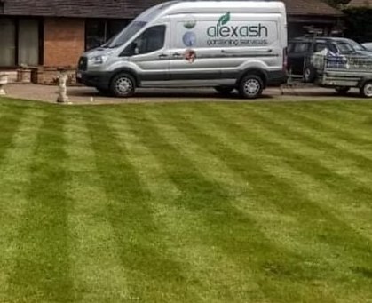 The Alex Ash Gardening Services van parked beside a freshly striped lawn